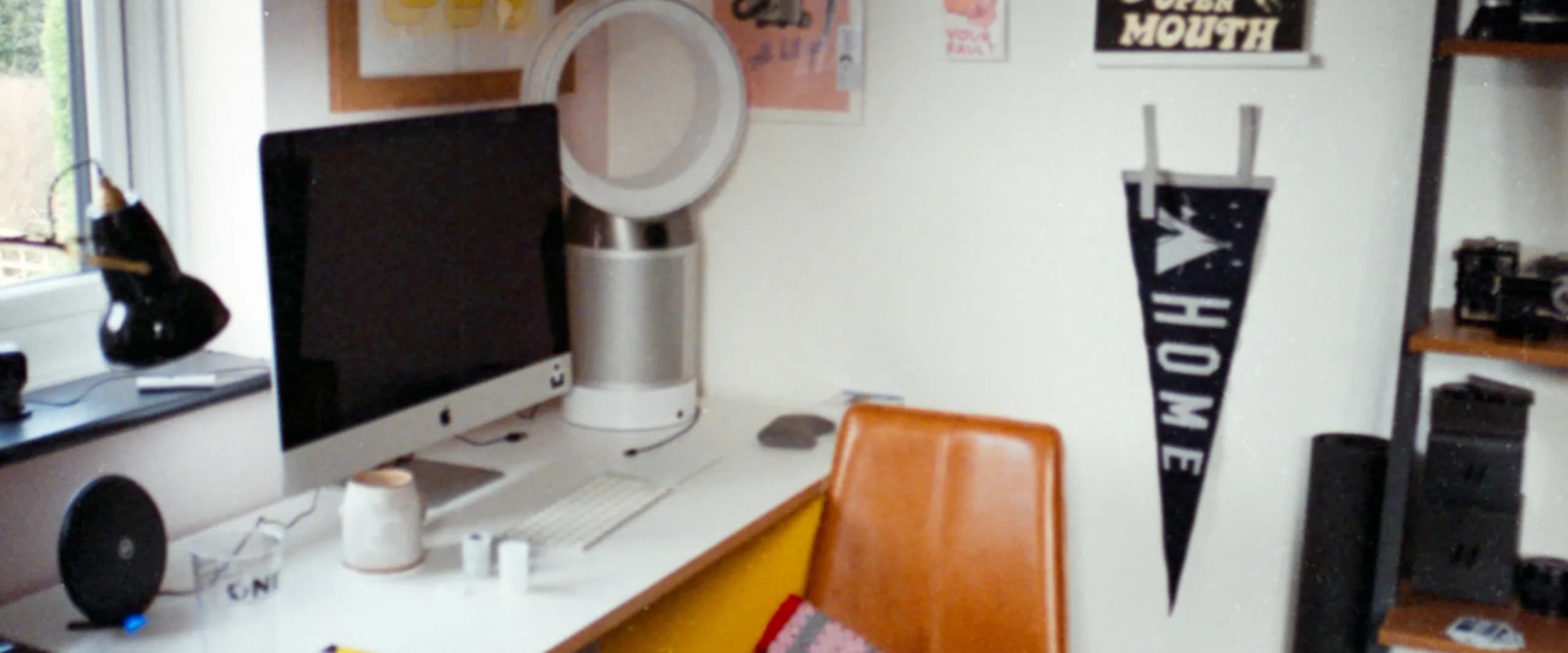 A quiet shared workspace with books, notebooks, and materials arranged across a long table.