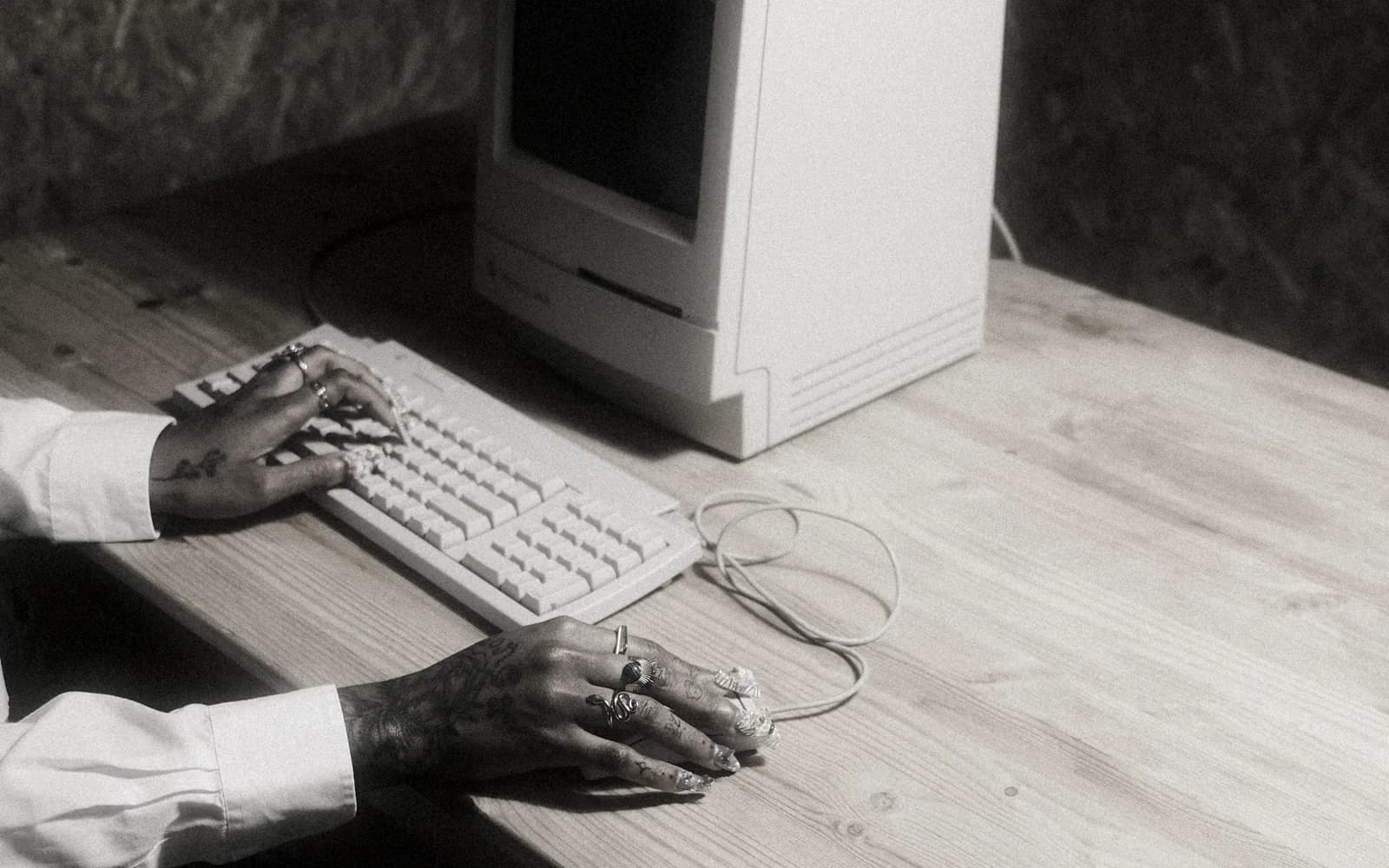 A person operating an early personal computer, when every capability still waited at the keyboard.